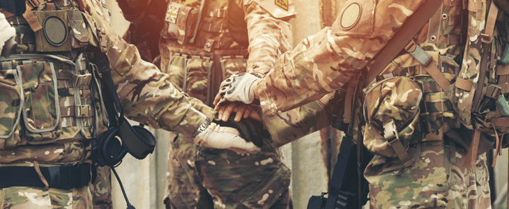 closeup of military people holding hands